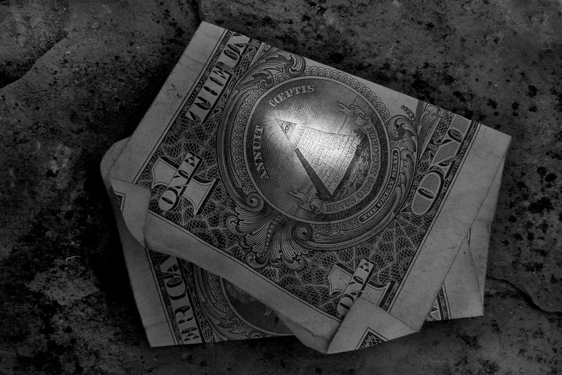 Black and white dollar highlighting  the illumanati symbol